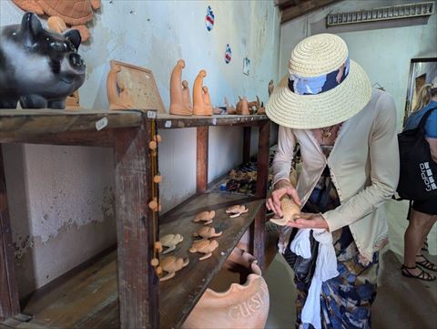 Visitante a conhecer peças artesanais na olaria de Rabil, Boa Vista